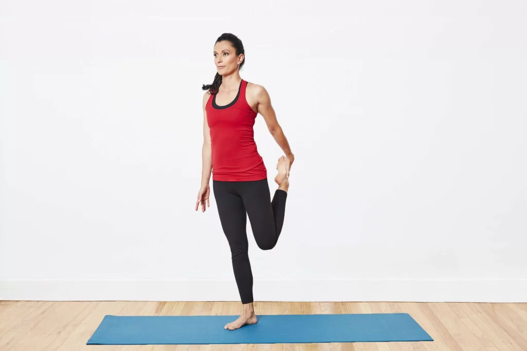 While standing, flex your quadriceps.